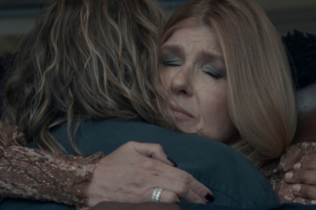 Connie Britton hugging someone with her eyes closed. 