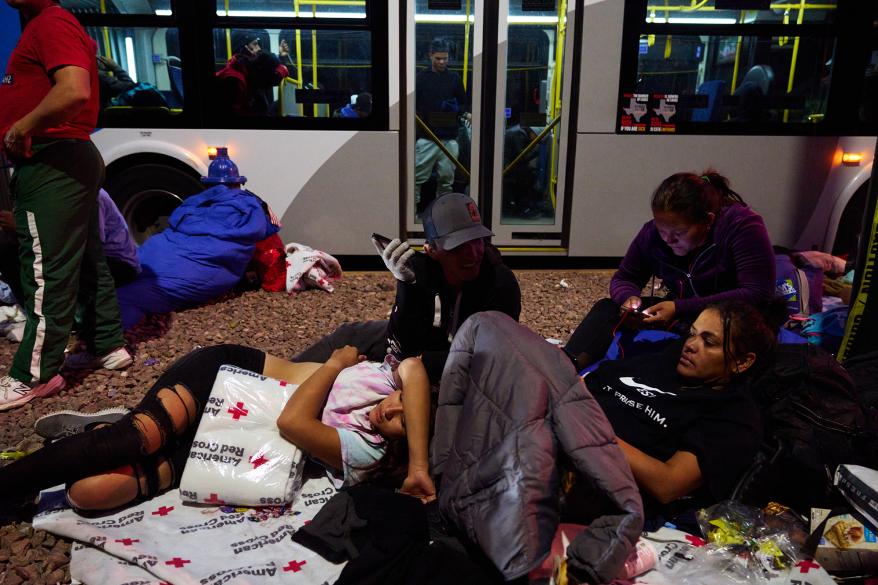 Migrants wait to enter an overnight shelter at Sacred Heart Church.