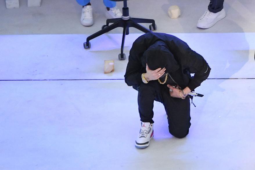 Eminem kneels on stage during the halftime show of Super Bowl LVI between the Los Angeles Rams and the Cincinnati Bengals at SoFi Stadium in Inglewood, California, on Feb. 13, 2022.