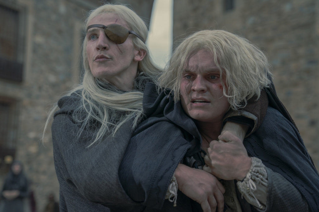 Ewan Mitchell, 25, and Tom, Glynn-Carney, 27, as Alicent's sons Aemond and Aegon on "House of the Dragon" with their arms around each other snarling. 