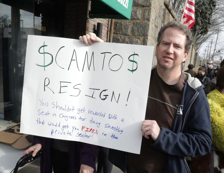 Tom Kearney, 53, holding a sign