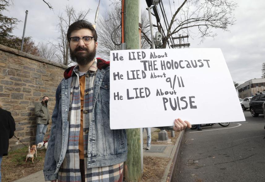 Protestor Gregory Canell 26, holding a sign