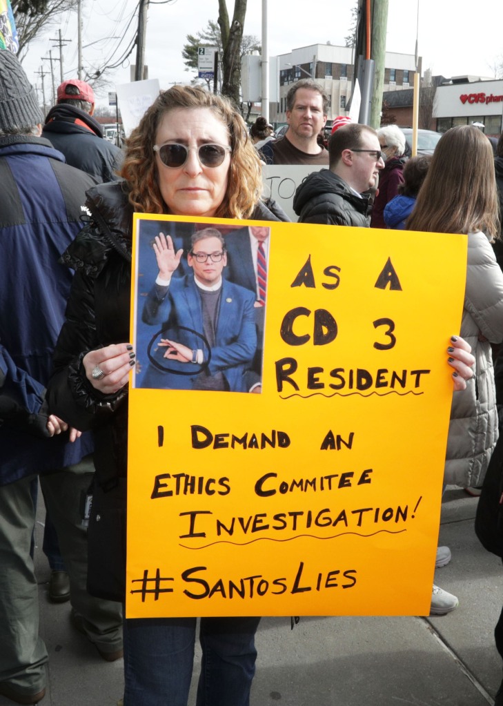 George Santos protester holds a sign