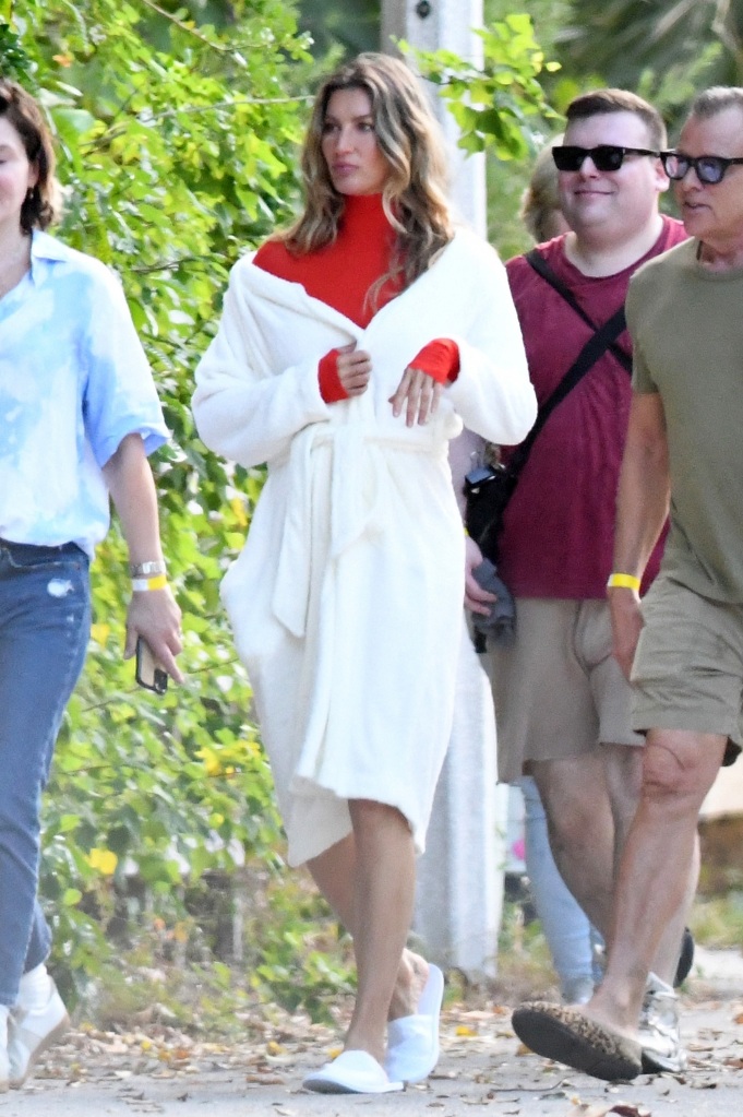 Bündchen sports a red body suit in another look during the beach shoot.