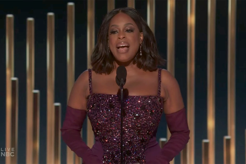 Niecy Nash. She's wearing a red sparkly dress and red, arm-length gloves.