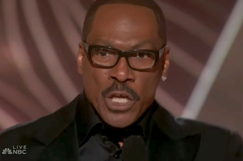 Eddie Murphy on stage. He's wearing glasses and has a mustache.