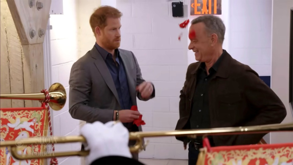 Prince Harry pretends to throw rose petals over Tom Hanks.