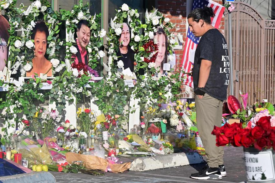 People pays their respect at a makeshift memorial for victims of a mass shooting in front of the Star Ballroom Dance Studio