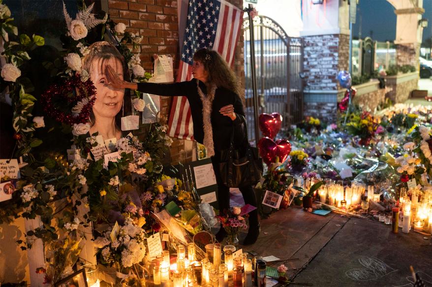 Adele Castro, 68, who said she knew all the victims, touches the photo of Mymy Nhan at a memorial outside Star Dance Studio