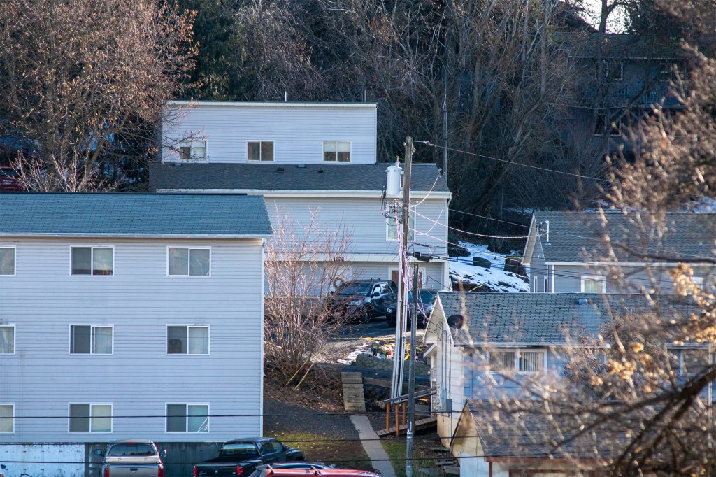 In this image, taken from Nez Perce Drive on the University of Idaho campus,a pair of private security company vehicles sit outside the house where Bryan Kohberger allegedly stabbed four university students to death. 