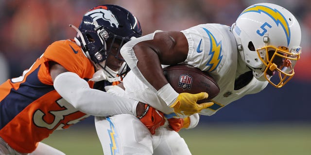 Ja'Quan McMillian #35 of the Denver Broncos tackles Joshua Palmer #5 of the Los Angeles Chargers during the fourth quarter at Empower Field At Mile High on January 08, 2023 in Denver, Colorado.