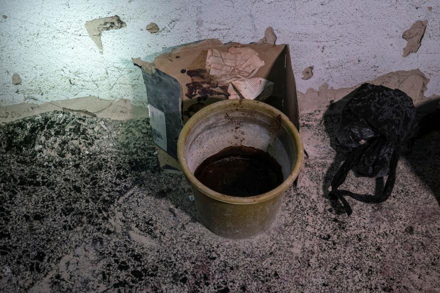 A bucket filled with human feces is seen at the makeshift detention center, where people were held in cramped rooms without sanitation.