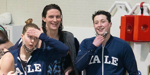 University of Pennsylvania swimmer Lia Thomas (C) smiles with Yale University swimmer Iszac Henig (right) after winning the 100 yard freestyle during the 2022 Ivy League Womens Swimming and Diving Championships at Blodgett Pool on February 19, 2022, in Cambridge, Massachusetts.