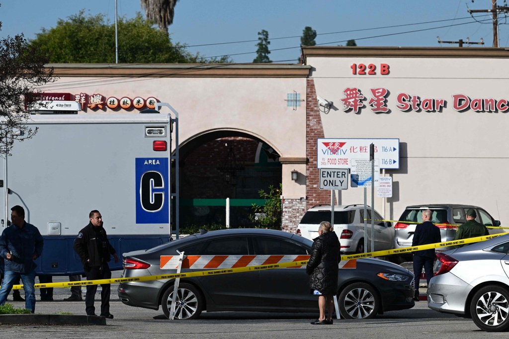 Local residents watch police investigate the scene of a mass shooting in Monterey Park.