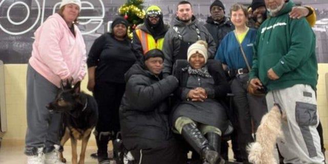 Jay Withey, 27, is pictured center, surrounded by some of the people he helped find shelter from the deadly winter storm in Western New York in December. 