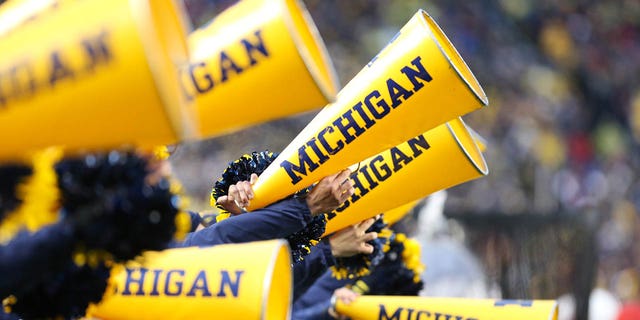 A general view of the Michigan cheerleaders shouting into their megaphones on November 12, 2022 at Michigan Stadium in Ann Arbor, Michigan. 