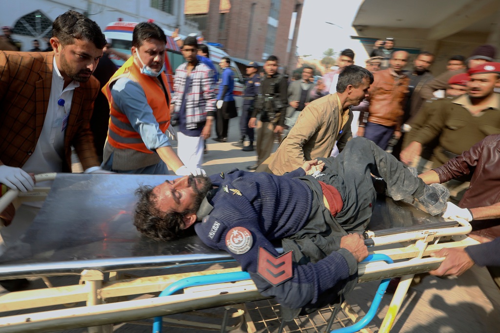 Workers and volunteers carry an injured victim of a suicide bombing upon arrival at a hospital in Peshawar, Pakistan on Jan. 30, 2023.
