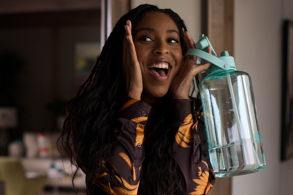 Jessica Williams as Gabby. She's holding a water bottle with her hands on her face imitating Macaulay Culkin's famous "Home Alone" look.