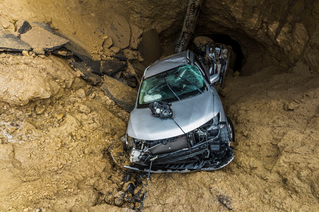 The damaged vehicles pictured in the sinkhole after the rescue.