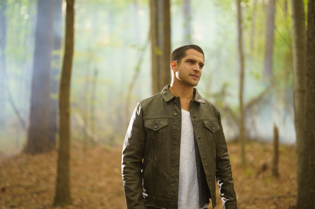 Tyler Posey as Scott McCall in "Teen Wolf: The Movie" standing by trees. 