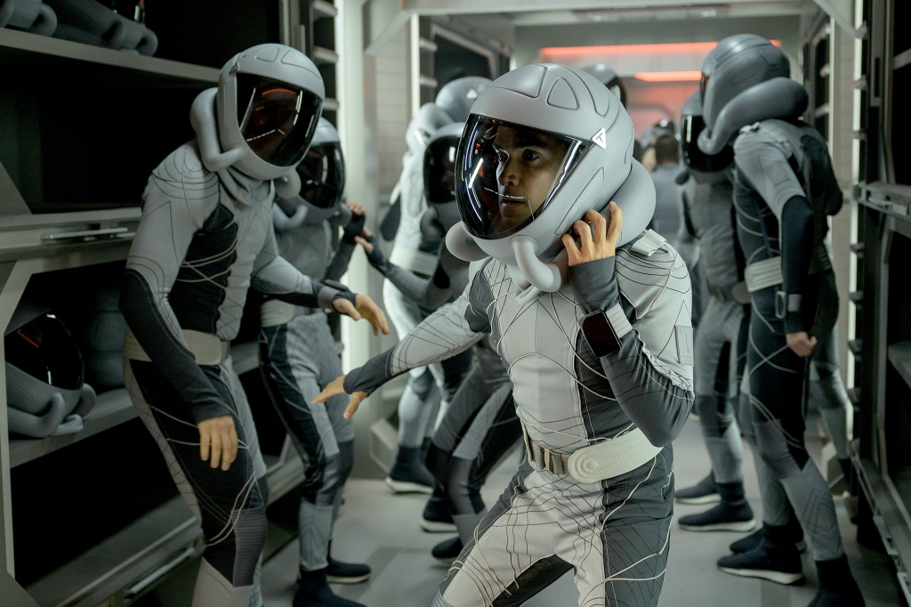 Image of Lt. Lane (Reece Ritchie) on board the spaceship. He's wearing a white spacesuit and a white space helmet.