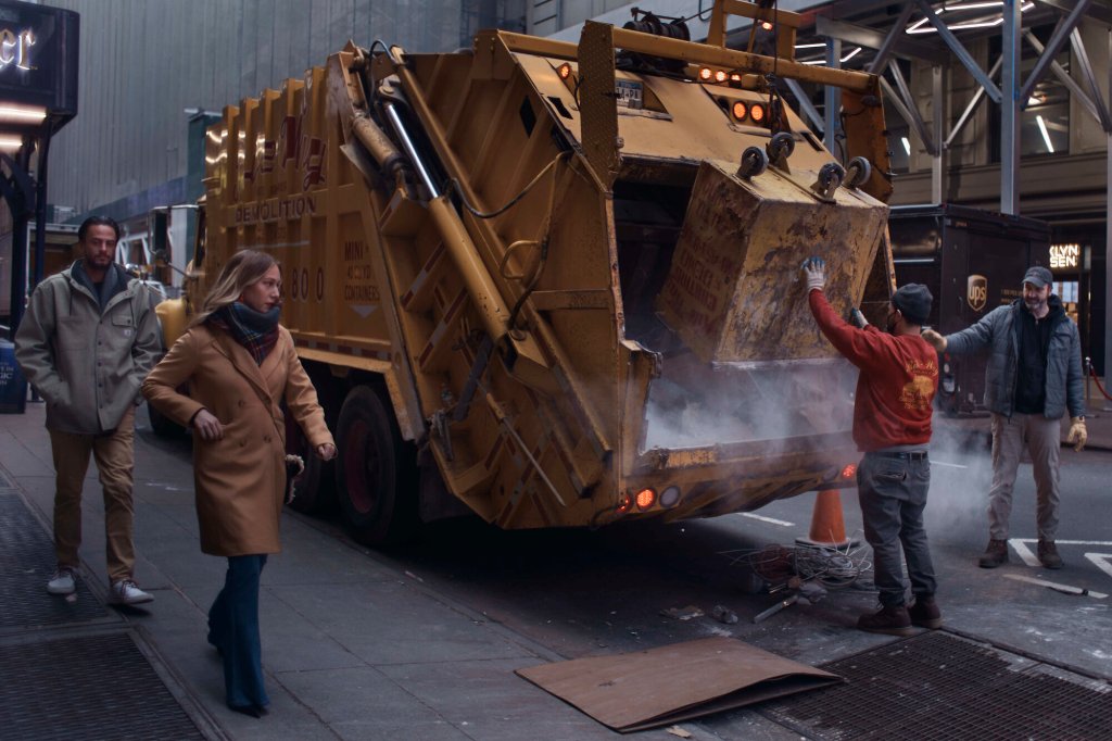 Construction workers dispose material as a couple passes by on Tuesday, Jan. 17, 2023, in New York. 