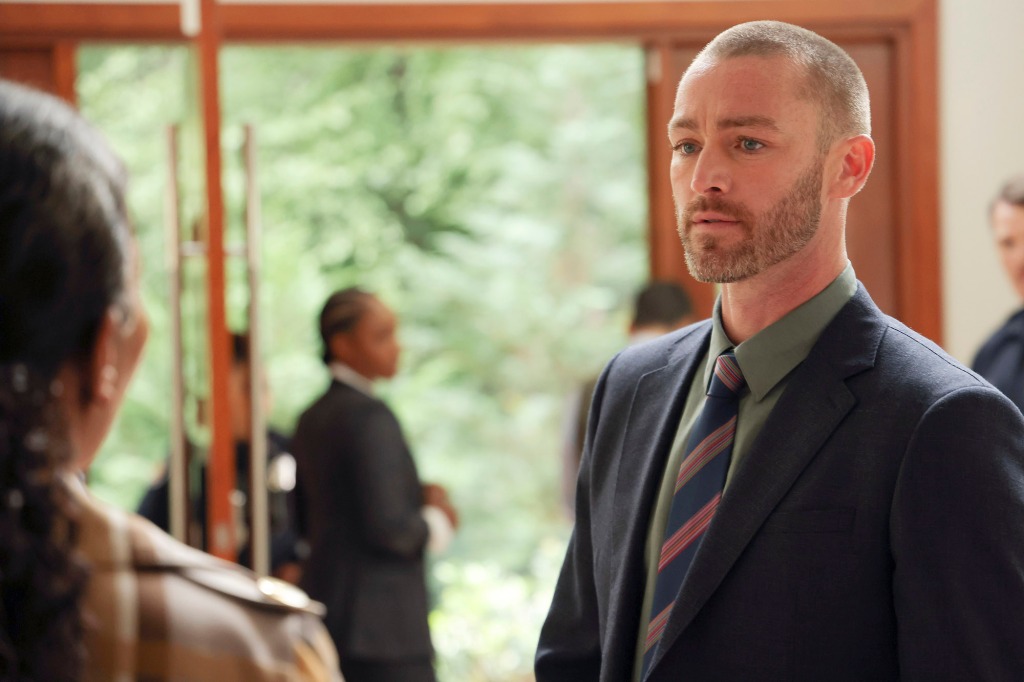 Jake McLaughlin as Det. Michael Ormewood in a scene from "Will Trent." He's wearing a suit and tie and has a closely-cropped beard. He's talking to someone whose back is to the camera.