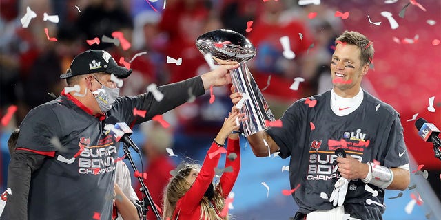 Super Bowl MVP Tom Brady of the Buccaneers accepts the Lombardi Trophy from general manager Jason Licht after Super Bowl LV between the Kansas City Chiefs and the Tampa Bay Buccaneers Feb. 7, 2021, at Raymond James Stadium, in Tampa, Fla. 