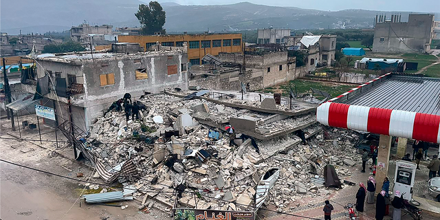 People search through the wreckage of a collapsed building in Azmarin town, in Idlib province, northern Syria.