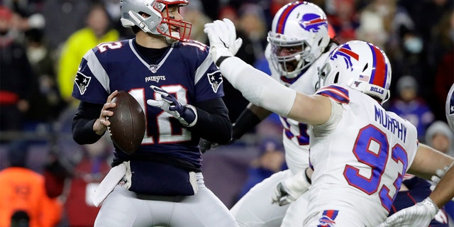 In this Dec. 21, 2019, file photo, New England Patriots quarterback Tom Brady, left, passes under pressure from Buffalo Bills defensive end Trent Murphy (93) during the first half of a game in Foxborough, Mass. 