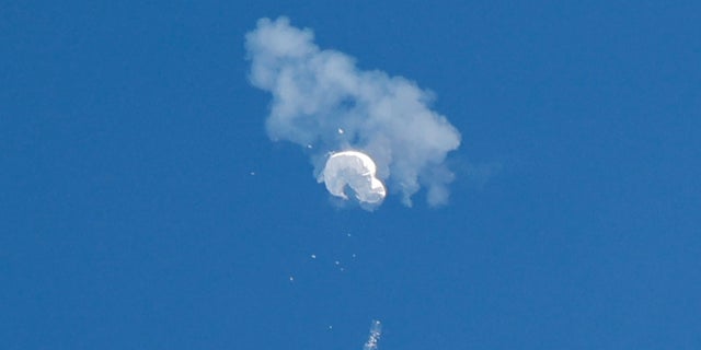 The suspected Chinese spy balloon drifts to the ocean after being shot down off the coast in Surfside Beach, S.C., on Saturday.