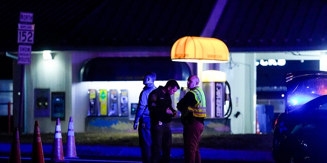 Police officers stand at a checkpoint on Mountain Road and Belair Road where a suspected gunman is believed to be at-large, Thursday, Feb. 9, 2023, in Fallston, Md.