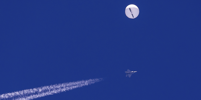 A large balloon drifts above the Atlantic Ocean, just off the coast of South Carolina, with a fighter jet and its contrail seen below it, on Feb. 4.