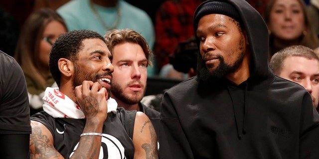 Kyrie Irving #11 (L) and Kevin Durant #7 of the Brooklyn Nets look on against the Los Angeles Lakers at Barclays Center on January 30, 2023 in New York City. 