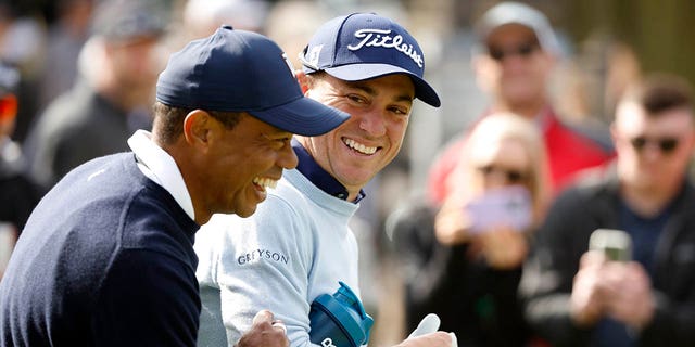 Tiger Woods of the United States and Justin Thomas of the United States walk across the ninth hole during the first round of the The Genesis Invitational at Riviera Country Club on February 16, 2023 in Pacific Palisades, California. 