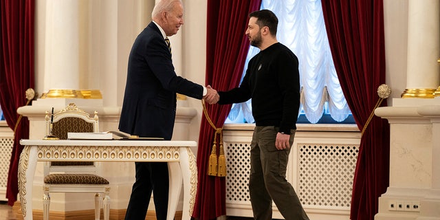 Ukraine's President Volodymyr Zelenskyy and U.S. President Joe Biden shake hands at Mariinsky Palace on an unannounced visit, in Kyiv, Ukraine, February 20, 2023. Biden has pledged total support for Ukraine with an additional half-billion dollars in funding for weaponry.