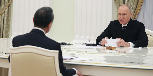 Russian President Vladimir Putin, right, speaks to the Chinese Communist Party's foreign policy chief Wang Yi during their meeting at the Kremlin on Feb. 22.