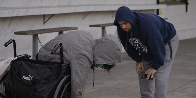 Rodriguez tries to rouse an addict passed out in a wheelchair. The activist warned the man that he would receive a Narcan dose if he didn't sit up.