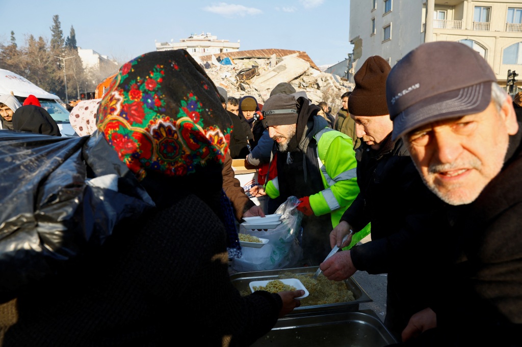Volunteers serve meals to people in the aftermath of a deadly earthquake in Kahramanmaras, Turkey, on Feb. 8, 2023. 