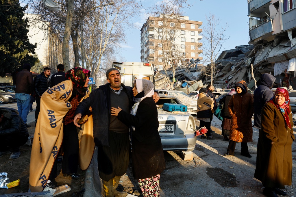 People, whose relatives are trapped under the rubble, react in the aftermath of the deadly earthquake in Kahramanmaras, Turkey, on Feb. 8, 2023.
