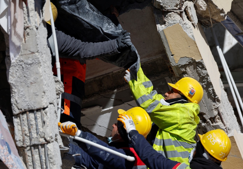 Rescue workers carry the body of a victim out of a damaged building in Kirikhan, Turkey on Feb. 9, 2023. 