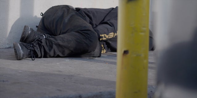 An addict lies on the sidewalk in Kensington. Rodriguez laments that they're seen as just parts of the neighborhood's landscape.