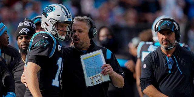 Carolina Panthers head coach Matt Rhule talks with quarterback Sam Darnold during the first half of a game against the Tampa Bay Buccaneers Dec. 26, 2021, in Charlotte, N.C.