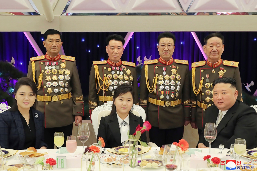 North Korean leader Kim Jong Un sits next to his wife Ri Sol Ju, left, and his daughter, as they pose with military top officials for a photo at the feast on Feb. 8, 2023 in North Korea.