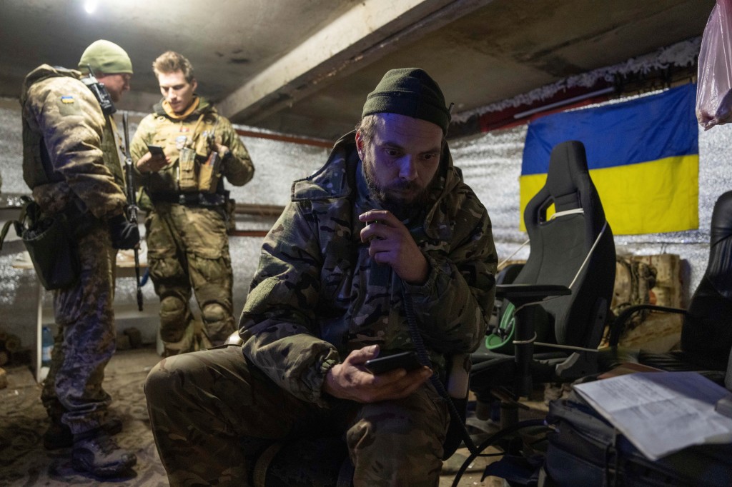 A Ukrainian marine serviceman on the radio in a shelter in Vuhledar.