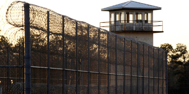 The sun sets behind Holman Prison in Atmore, Alabama, on Thursday, Jan., 27, 2022, as the U.S. Supreme Court considered whether to allow the execution of death row inmate Matthew Reeves, convicted of killing a man during a robbery in 1996.