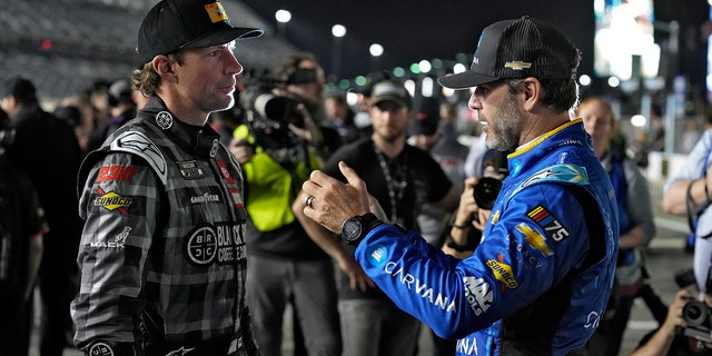 Jimmie Johnson, right, and Travis Pastrana talk before qualifying for the NASCAR Daytona 500 auto race Wednesday, Feb. 15, 2023, at Daytona International Speedway in Daytona Beach, Fla.