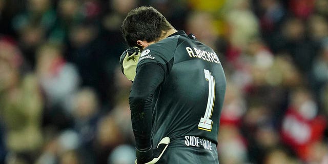 Liverpool's goalkeeper Alisson gestures after Real Madrid's Vinicius Junior scores his side's second goal during the Champions League, round of 16, first leg soccer match between Liverpool and Real Madrid at the Anfield stadium in Liverpool, England, Tuesday, Feb. 21, 2023.