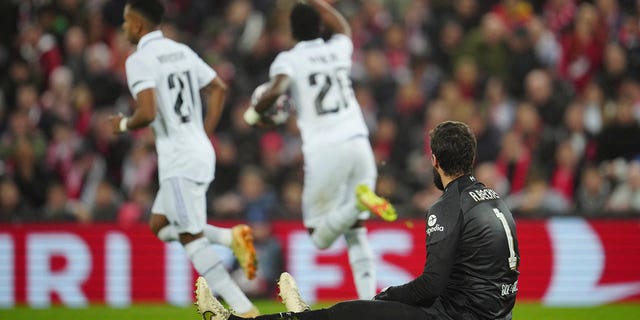 Liverpool's goalkeeper Alisson, bottom, gestures as Real Madrid's Vinicius Junior celebrates after scoring his side's opening goal during the Champions League, round of 16, first leg soccer match between Liverpool and Real Madrid at the Anfield stadium in Liverpool, England, Tuesday, Feb. 21, 2023.