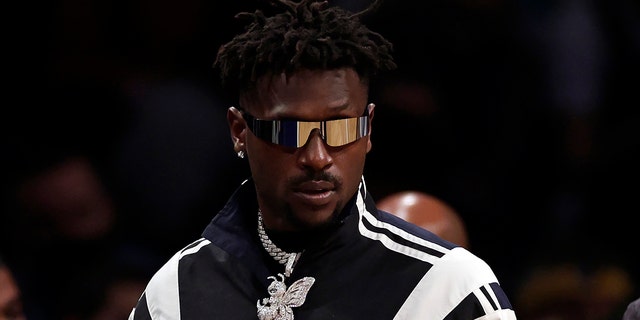 Former Tampa Bay Buccaneers wide receiver Antonio Brown arrives courtside during the second half of an NBA basketball game between the Memphis Grizzlies and the Brooklyn Nets Jan. 3, 2022, in New York.